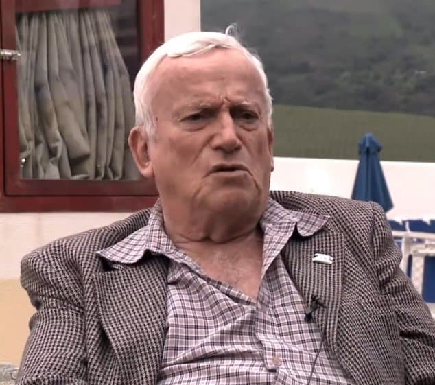 Portrait of Fruto Vivas, an elderly man with white hair wearing a tweed jacket