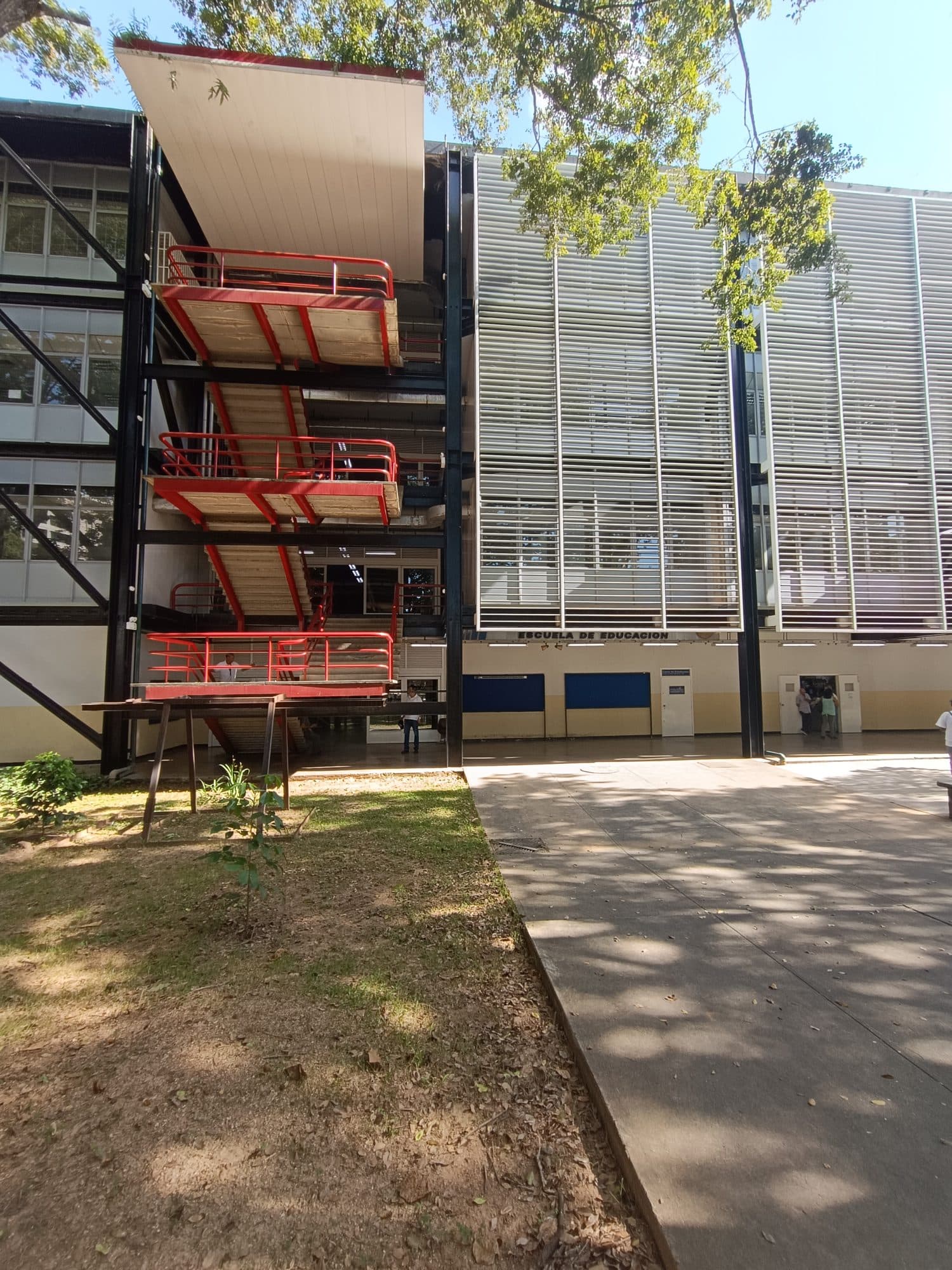 Edificio de Trasbordo at the UCV campus, showing its black bolted steel frame, red stair landings and louvred façade